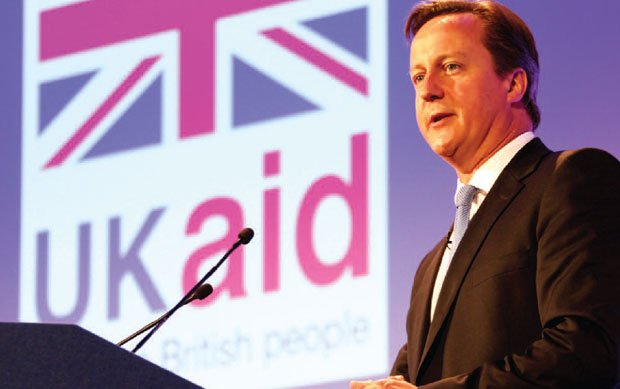 David Cameron speaks in front of the UK Aid logo