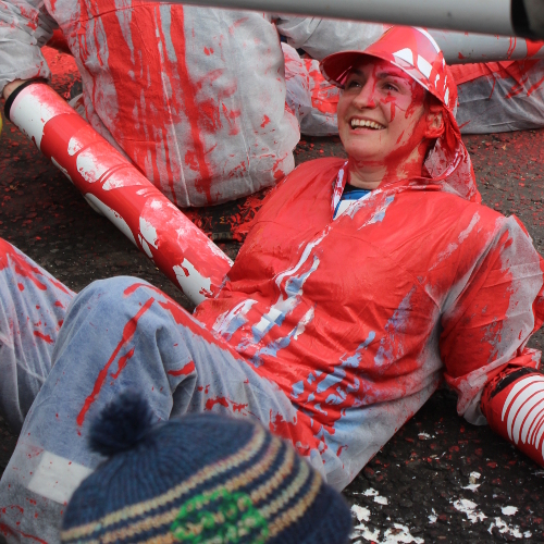 Cheerful protestor covered in red paint.