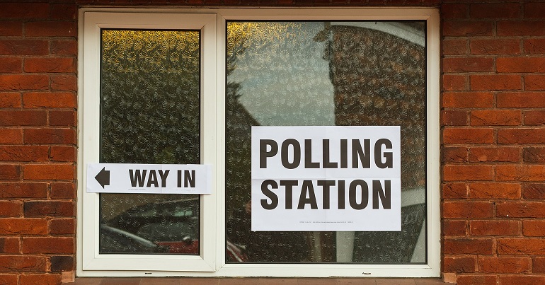 A photo of a window with a polling station sign