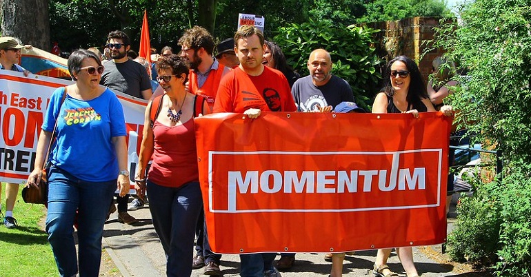 Campaigners marching behind a Momentum banner