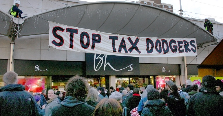 Banner reading "stop tax dodgers" across a branch of BHS