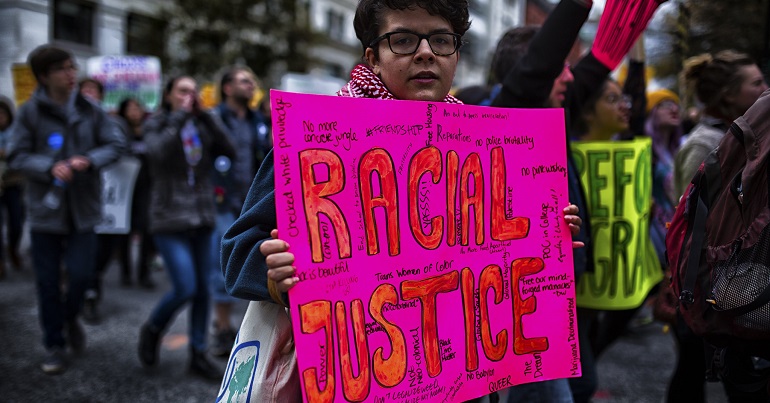 Protester with a placard reading "racial justice"