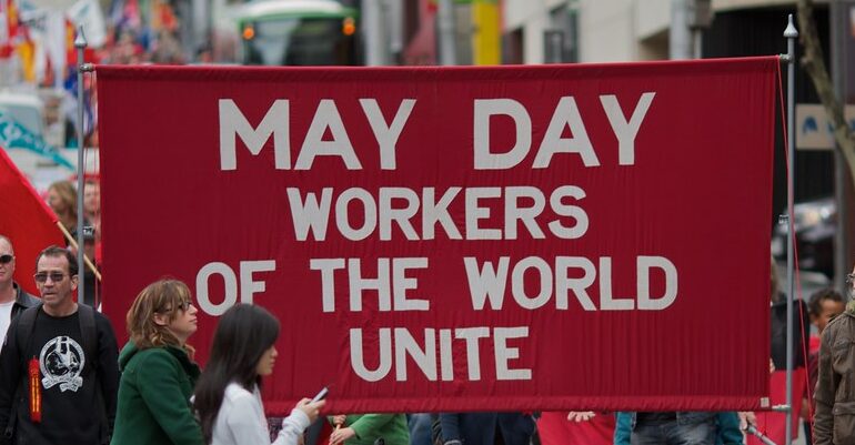 A banner for may day, reads workers of the world unite