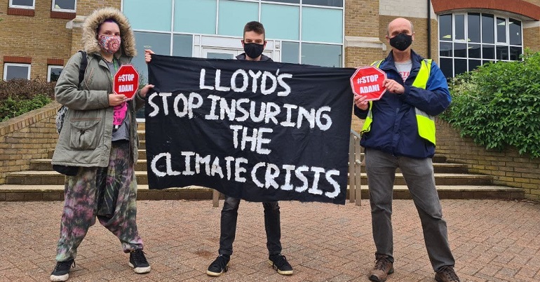 Climate protesters holding a banner reading "Lloyds stop insuring the climate crisis"