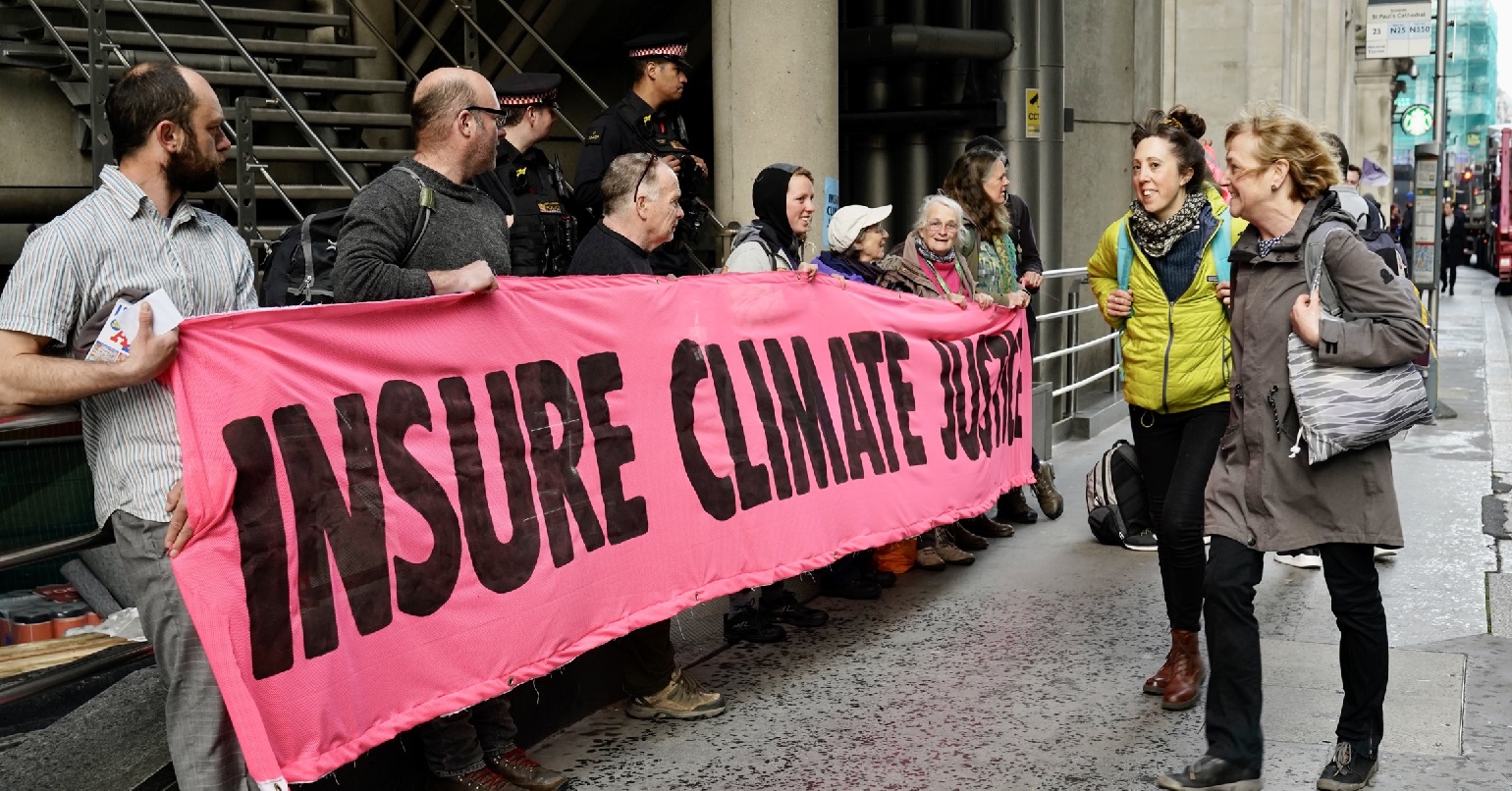 A photo of the Extinction Rebellion blockade of Lloyds of London HQ with activists holding a banner reading "insure climate justice"