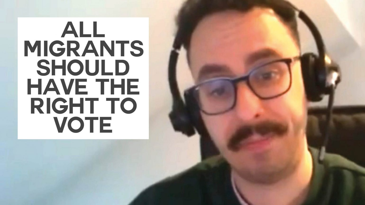 A still of an interview with Green Party migration spokesperson Benali Hamdache with text overlaid reading "All migrants should have the right to vote"