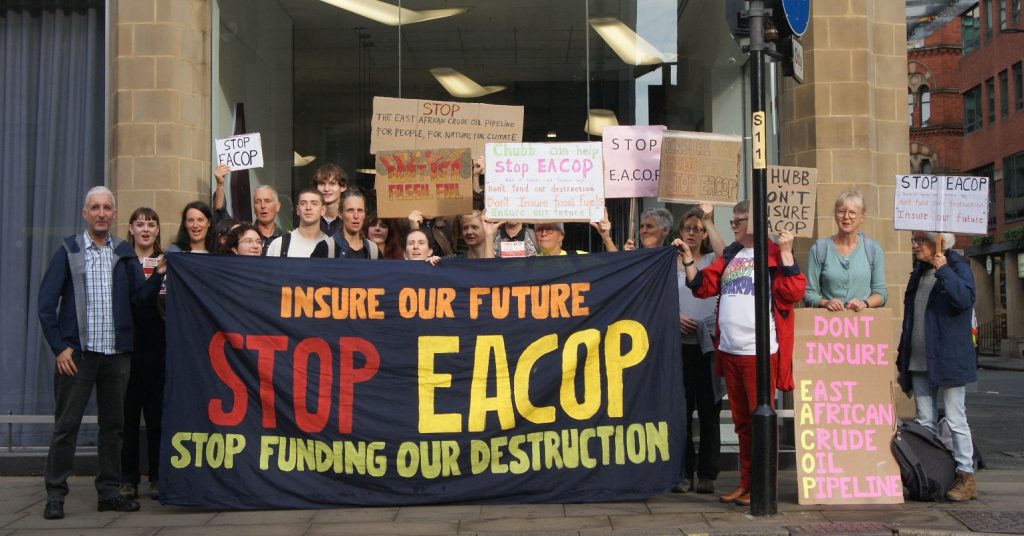 Protesters with a banner reading "Stop EACOP"