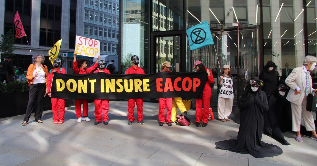 A photo of campaigners holding a banner reading "Don't Insure EACOP"