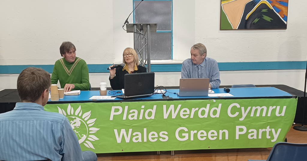Three people sitting at the front desk at Wales Green Party conference