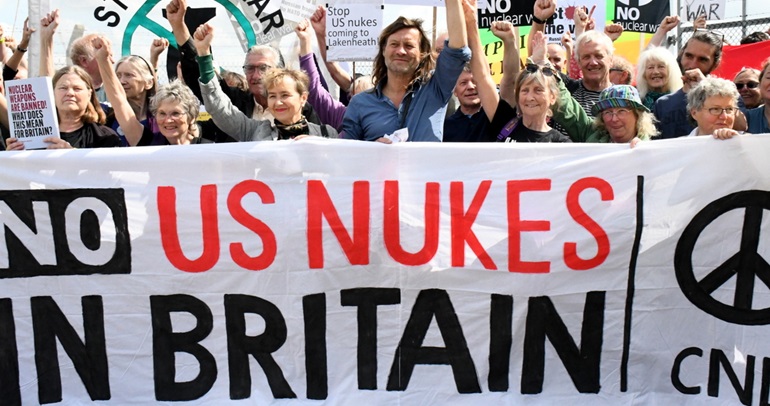 A photo of the front of a march. The banner at the front reads "No US nukes in Britain"